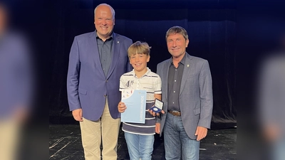 Nico Schimanski aus Unterföhring wurde für seinen Deutschen Meister im Para-Karte AK 8 geehrt. Ihm gratulierten Landrat Christoph Göbel (l.) und Bürgermeister Andreas Kemmelmeyer (r.). (Foto: hw)