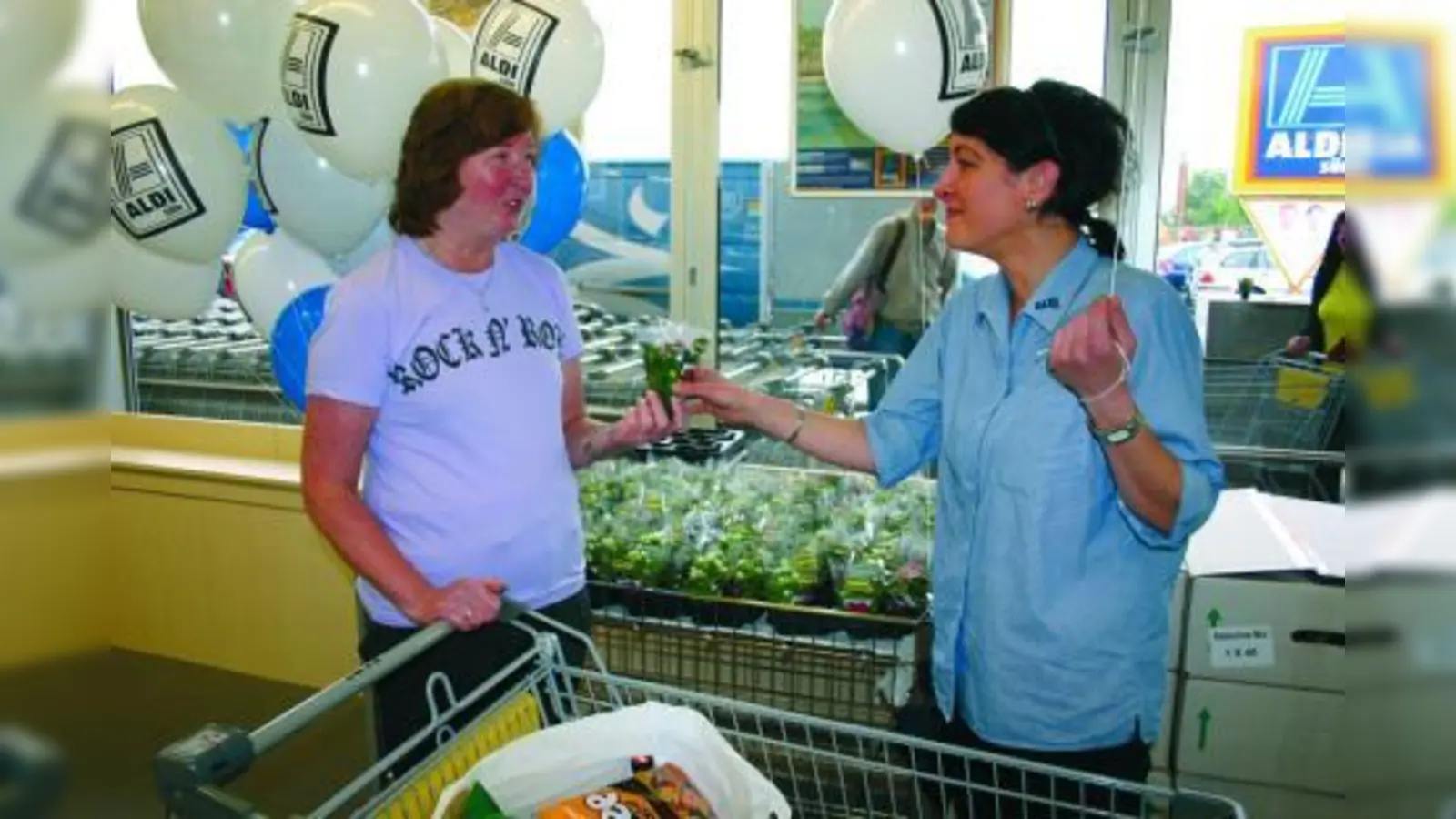 ALDI-Mitarbeiterin Marianne Semmling (r.) verteilte am Ausgang Blumen an die Kunden. (Foto: ls)