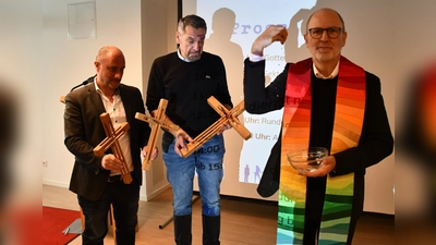 Der KJSW-Vereinsratsvorsitzende Klaus Peter Franzl segnet die neuen Kreuze fürs Haus und die Anwesenden. Die Kreuze halten die Leiter der kooperierenden KJSW-Einrichtungen: Thomas Frank vom Jugendwohn- und Gästehaus München-Süd (links) und Stefan Baumgartner vom Monsignore-Bleyer-Haus (Mitte). (Foto: Riffert/KJSW)