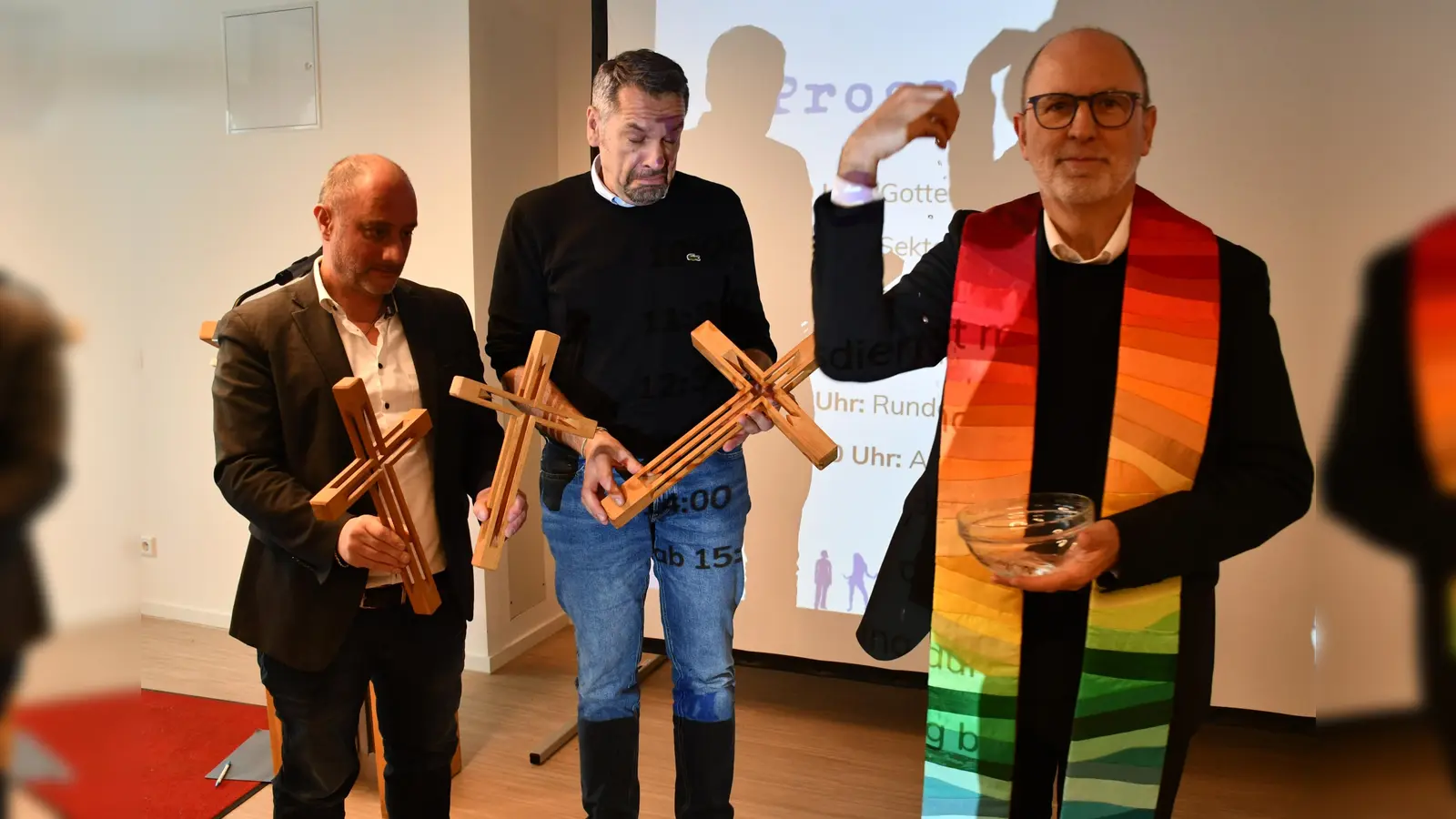 Der KJSW-Vereinsratsvorsitzende Klaus Peter Franzl segnet die neuen Kreuze fürs Haus und die Anwesenden. Die Kreuze halten die Leiter der kooperierenden KJSW-Einrichtungen: Thomas Frank vom Jugendwohn- und Gästehaus München-Süd (links) und Stefan Baumgartner vom Monsignore-Bleyer-Haus (Mitte). (Foto: Riffert/KJSW)