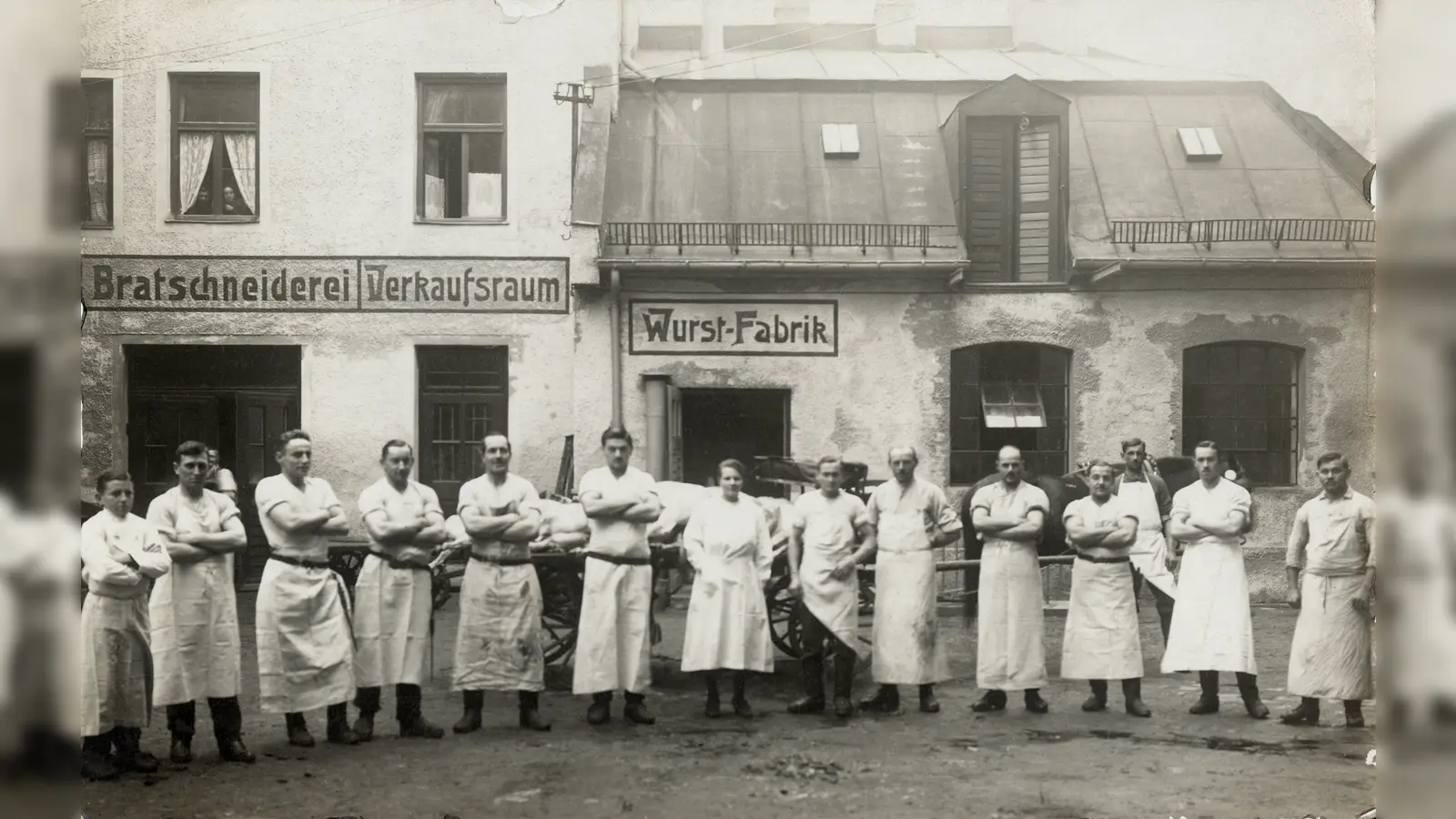Metzger vor den Produktionsgebäuden der Sendlinger Wurst-Fabrik, aufgenommen 1922. (Foto: Stadtarchiv München	DE-1992-FS-PK-STB-13936)
