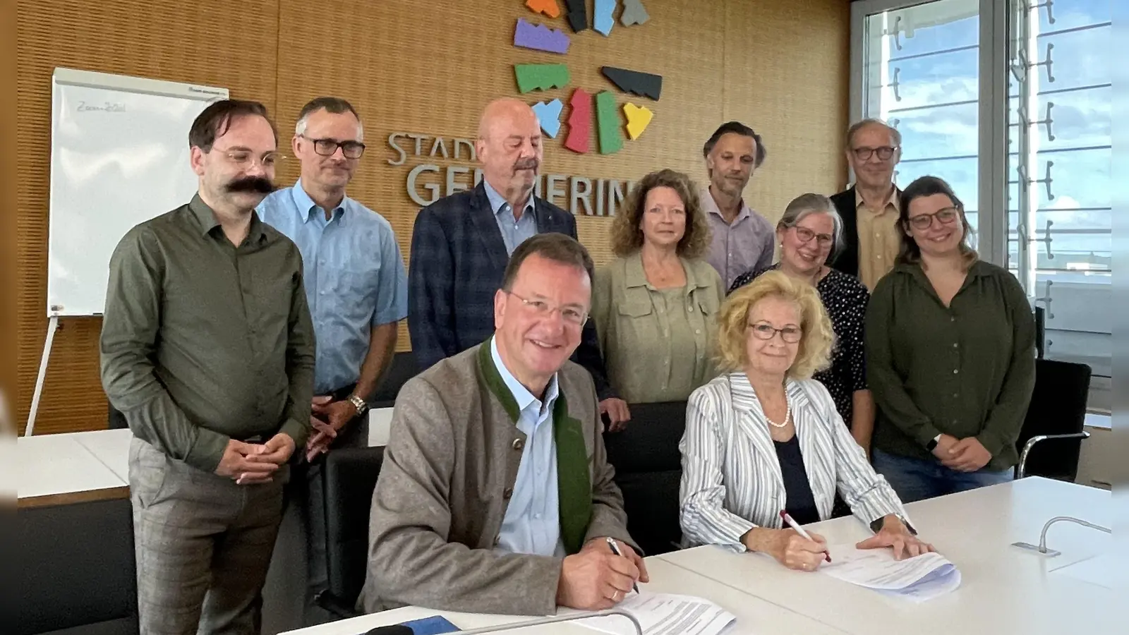 Den Vertrag unterzeichnen Andreas Haas und Sabine Schomburg (2. AWO-Vorsitzende). Stehend v.l.: Johannes Landendinger (Stadtrat), René Mroncz (Kämmerer), Helmut Lindauer (AWO-Vorsitz), Brit Hupp-Alter ( AWO), Martin Rattenberger (Stadt), Saskia Schon (AWO), Helmut Gallecker (Liegenschaften) und die künftige Kitaleitung Ines Klußmann. (Foto: pst)