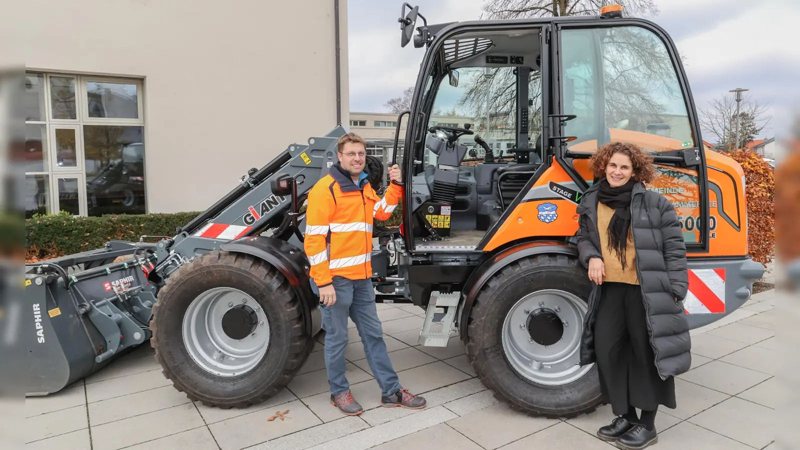 Bauhofleiter Josef Mörtl und Kämmerin Miryam Goodwin mit dem neuen Teleskop-Radlader vor dem Rathaus Herrsching.  (Foto: Gemeinde Herrsching)
