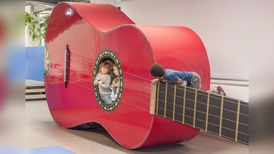Das Kinderreich im Deutschen Museum: In der roten Riesengitarre kann man erleben, wie es sich anfühlt, wenn draußen jemand an den Saiten zupft. (Foto: Deutsches Museum)