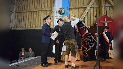 Bürgermeister Holger Jerg beim Befestigen des Fahnenbanners mit Vorstand Peter Voit und Kommandant Markus Mende. (Foto: W. Mende)