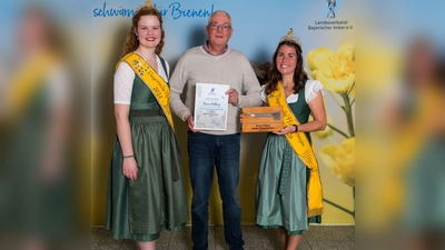 Der Hallbergmooser Imker Bruno Willing mit der bayerischen Honigkönigin Elena Eberl (r.) und der bayerischen Honigprinzessin Anja Bürzer samt seiner Goldmedaille und graviertem Stockmeißel. (Foto: LVBI)