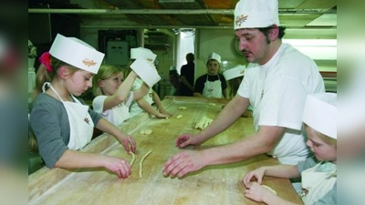 Gar nicht so einfach, selbst Laugengebäck herzustellen! Doch Bäcker Martin Reicherzer (r.) stand den Kindern der Grundschule an der Limesstraße mit Rat und Tat zur Seite. (Foto: pi)