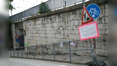 Radfahrer sind derzeit in Pasing besonders gefährdet. Baustellenbetreiber werben nun verstärkt um Aufmerksamkeit auch mit selbst gemalten Schildern, zum Beispiel an der Baustelle in der Bahn-Unterführung. (Foto: US)