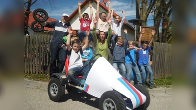 Alexander (vorne) wird in seiner Rennkiste von allen angefeuert: v.l. Organisator Andreas Heb mit Kindern der Jugend- und Kinderfeuerwehr Unterbrunn und Alexandra Heb (m.), Leiterin der Kinderfeuerwehr Unterbrunn. (Foto: © Andreas Heb)