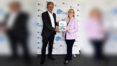 Klimaschutzmanagerin Dr.-Ing. Malgorzata Kroban übergibt Landrat Thomas Karmasin den fertiggestellten Energienutzungsplan für den Landkreis Fürstenfeldbruck. (Foto: LRA FFB)
