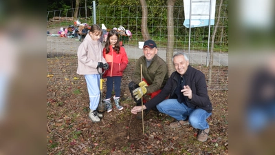 Puchheims Bürgermeister Norbert Seidl (re.) und Forstwirt Ricardo Steinig mit Kindern an einer neu gepflanzten Wildbirne  (Foto: M. Koch/AELF)