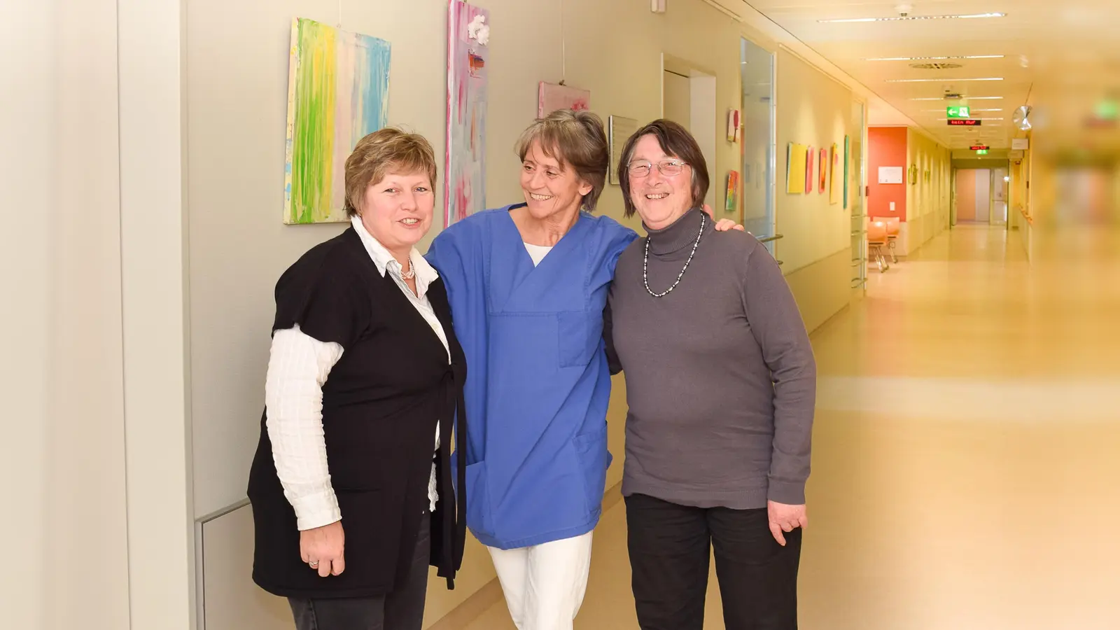 Jutta Fink, Chefärztin Prof. Cornelia Höß und Renate Kinzel (von links) in der Ambulanz Gynäkologie vor Bildern, die im Kinderkunstworkshop innerhalb des "Ebersberger Kleeblatts" gemalt wurden. (Foto: KK)
