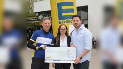 Katharina und Robin Grosjean (EDEKA Isargärten) übergaben Tour-Organisator Alexander Elskamp (links) eine Spende in Höhe von 707 Euro. (Foto: job)