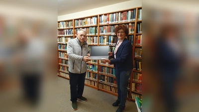 Einrichtungsleiterin Christiane Igl übergibt dem neuen Bibliothekar den Laptop. (Foto: Petra Sachs)