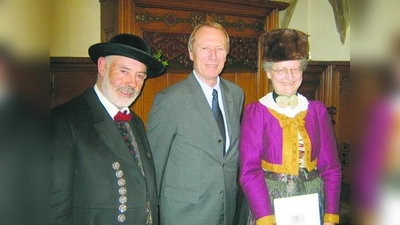 Josef Kinast in der Dachauer Tracht des Vereins für Volksmusik und Volkstanz „D' Blutenburgler“ (l.) und Ingrid Menzinger in der Menzinger Tracht des Heimat- und Volkstrachtenvereins „D' Würmtaler Menzing“ (r.) mit Bürgermeister Hep Monatzeder. (Foto: Frieder Vogelsgesang)