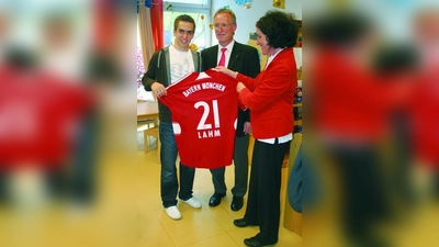 Philipp Lahm übergibt ein signiertes Trikot an Dr. Kay Vorwerk (M.) und Erika Rupp. (Foto: ls)