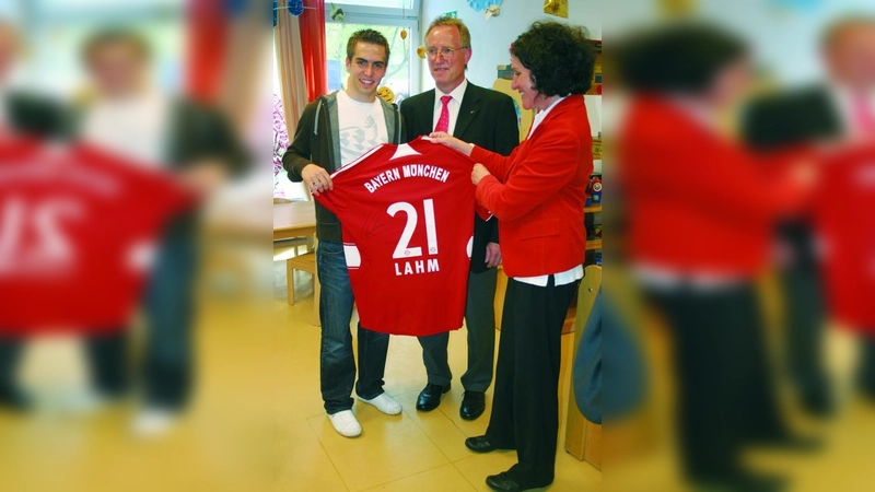 Philipp Lahm übergibt ein signiertes Trikot an Dr. Kay Vorwerk (M.) und Erika Rupp. (Foto: ls)