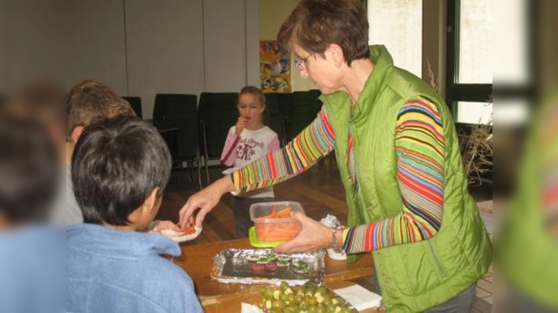Lehrerin Martha Taufer verteilt am gesunden Frühstücksbüfett Gemüse und Obst an die Schüler. (Foto: Mariani Peter)