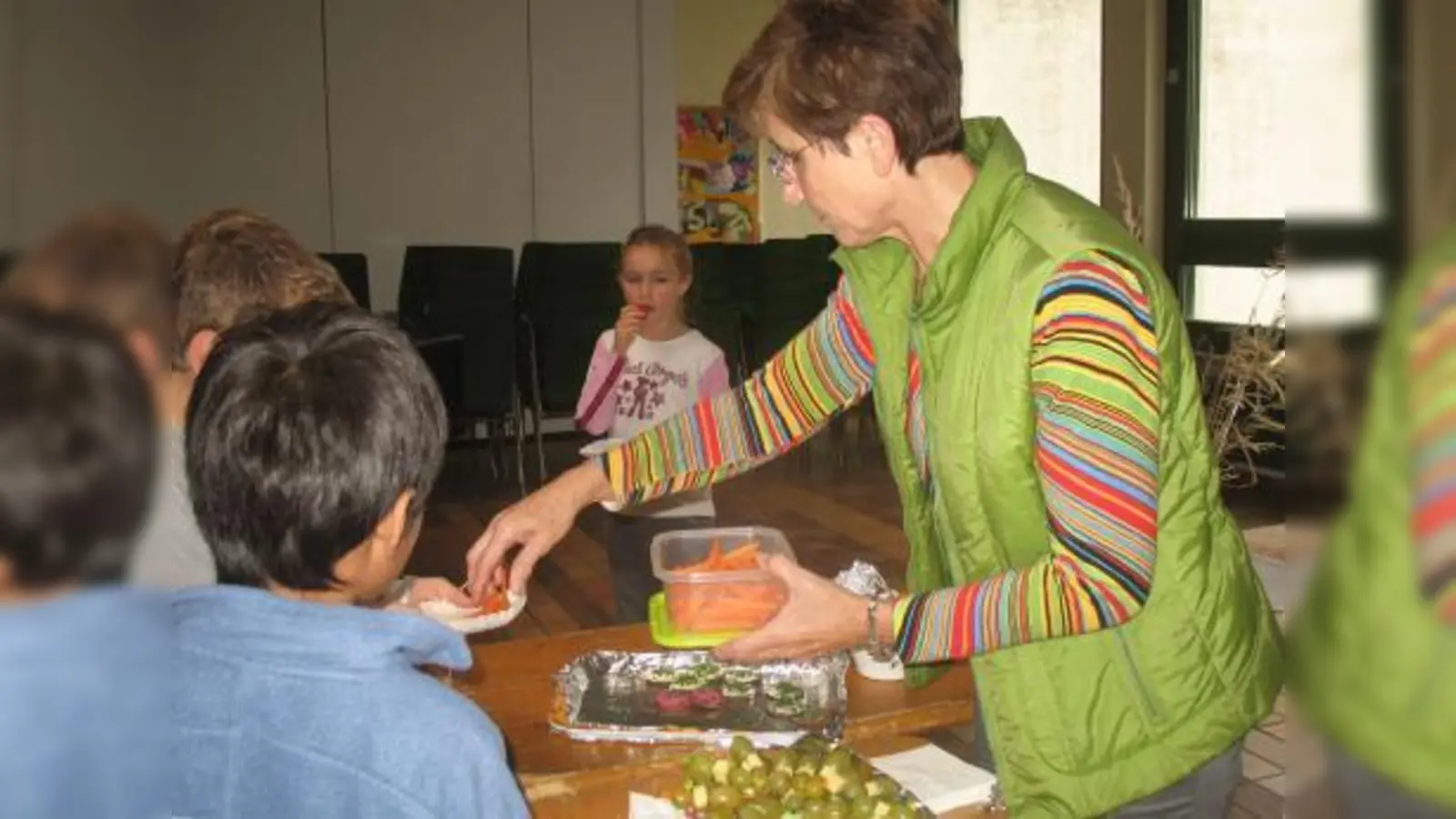 Lehrerin Martha Taufer verteilt am gesunden Frühstücksbüfett Gemüse und Obst an die Schüler. (Foto: Mariani Peter)