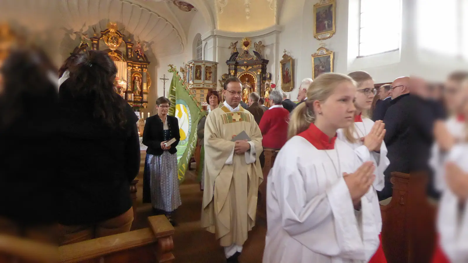 KLB-Ortsvorsitzende Maria Galleneder, KLB-Diözesanvorsitzende Luise Braun (mit der KLB-Fahne) und Pfarrer Siegfried Schöpf (v. li.). (Foto: Johanna Mühlfeld)