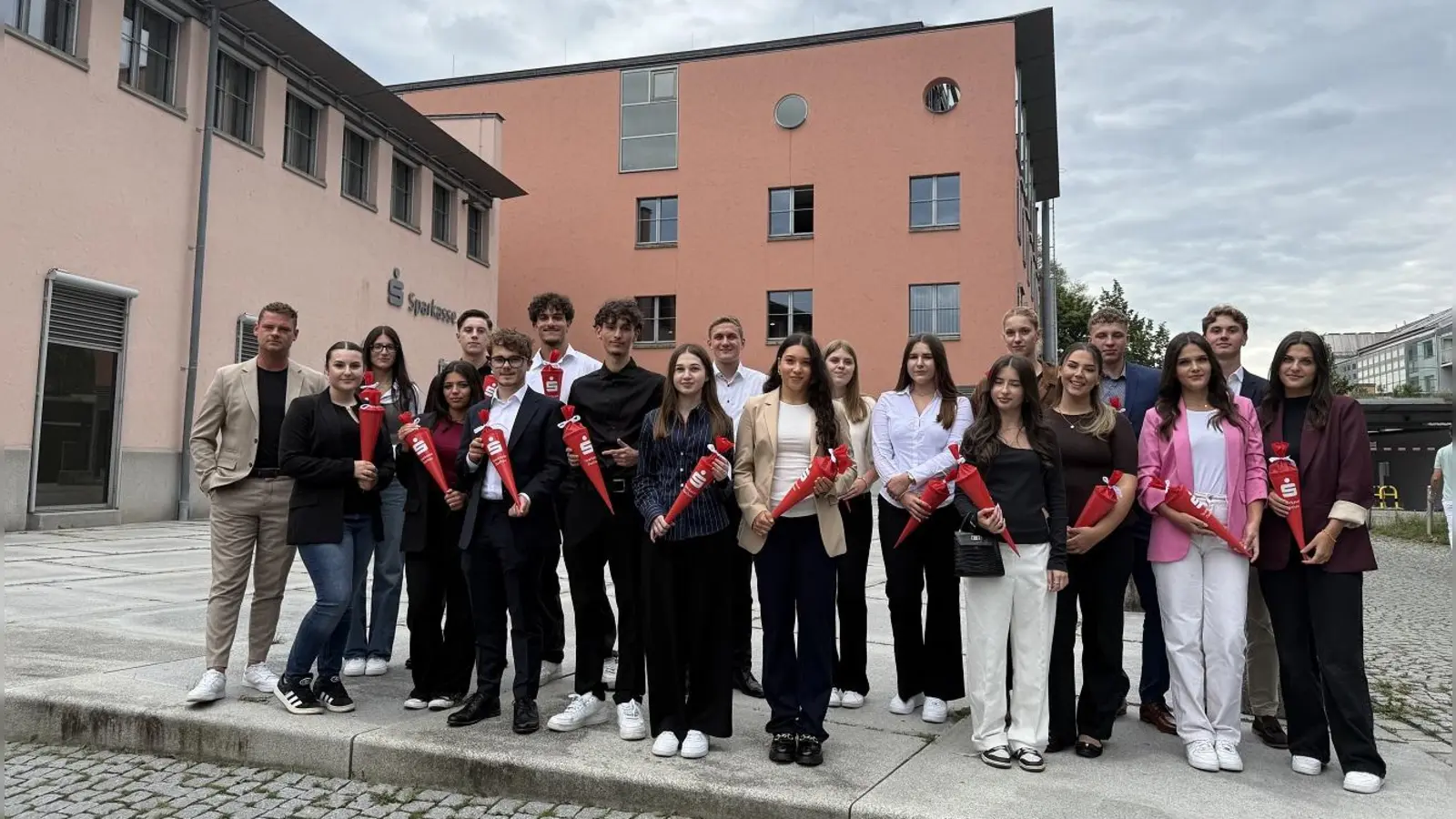 Die neuen Mitarbeiterinnen und Mitarbeiter haben eine eigene kleine Schultüte von ihrem Ausbildungsleiter Tim Euler (l.) erhalten.  (Foto: Sparkasse Dachau)