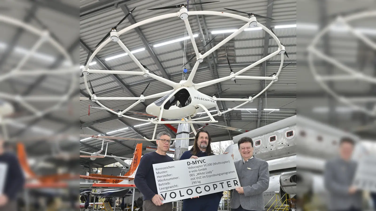 Volocopter-Mitgründer Stephan Wolf mit Alexander Zosel, der 2016 den Erstflug in der „White Lady” absolvierte, und dem Generaldirektor des Deutschen Museums, Wolfgang M. Heckl, (v. li.) bei der Übergabe des Flugtaxis in der Flugwerft Schleißheim. (Foto: Deutsches Museum)