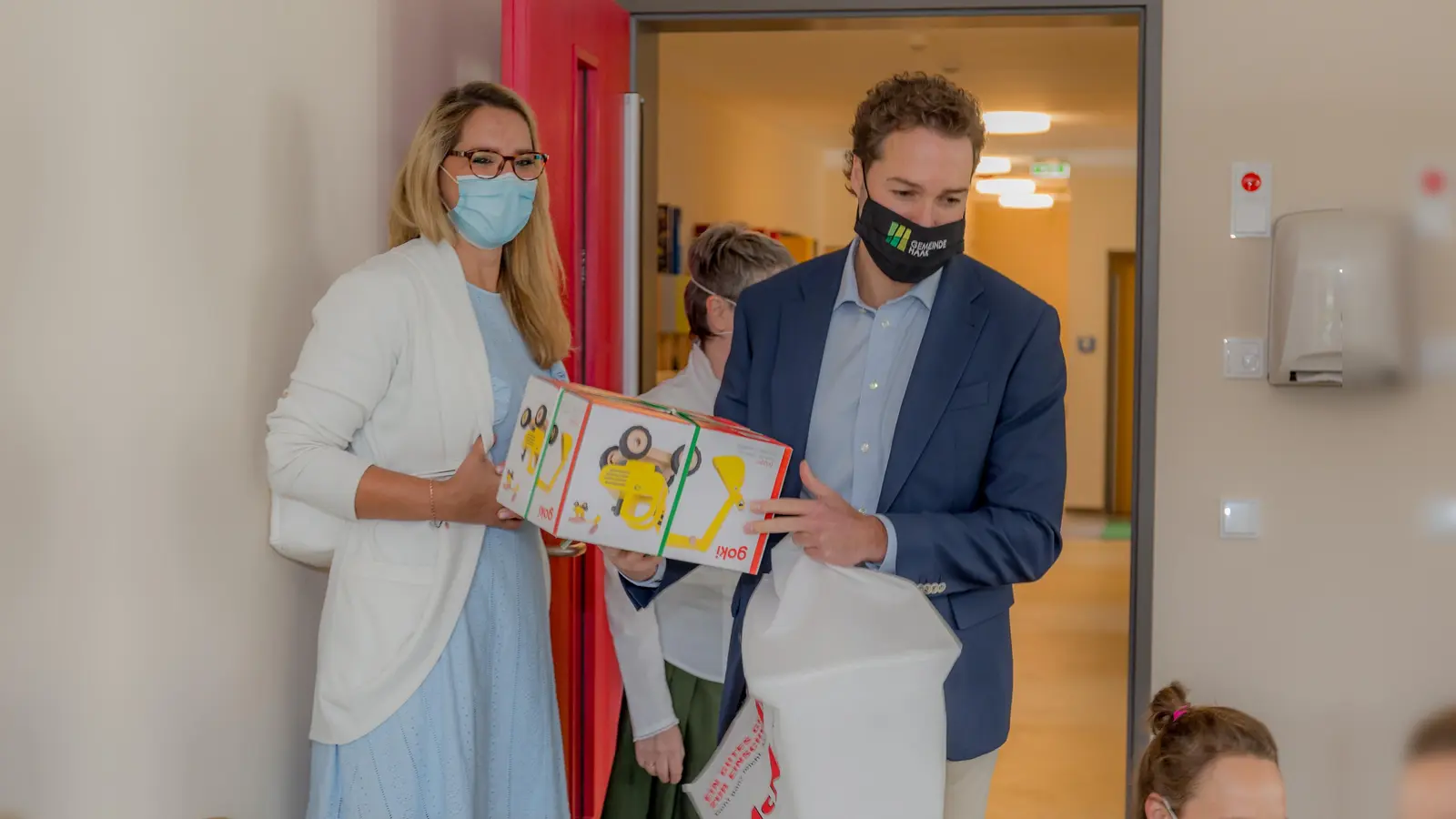 Zur Eröffnung des neuen Gronsdorfer Kindergarten brachten Kerstin Onwuama (Leitung Bildung und Soziales der Gemeinde Haar) und Bürgermeister Dr. Andreas Bukowski ein Geschenk für die Kinder mit. (Foto: Gmeinde Haar)
