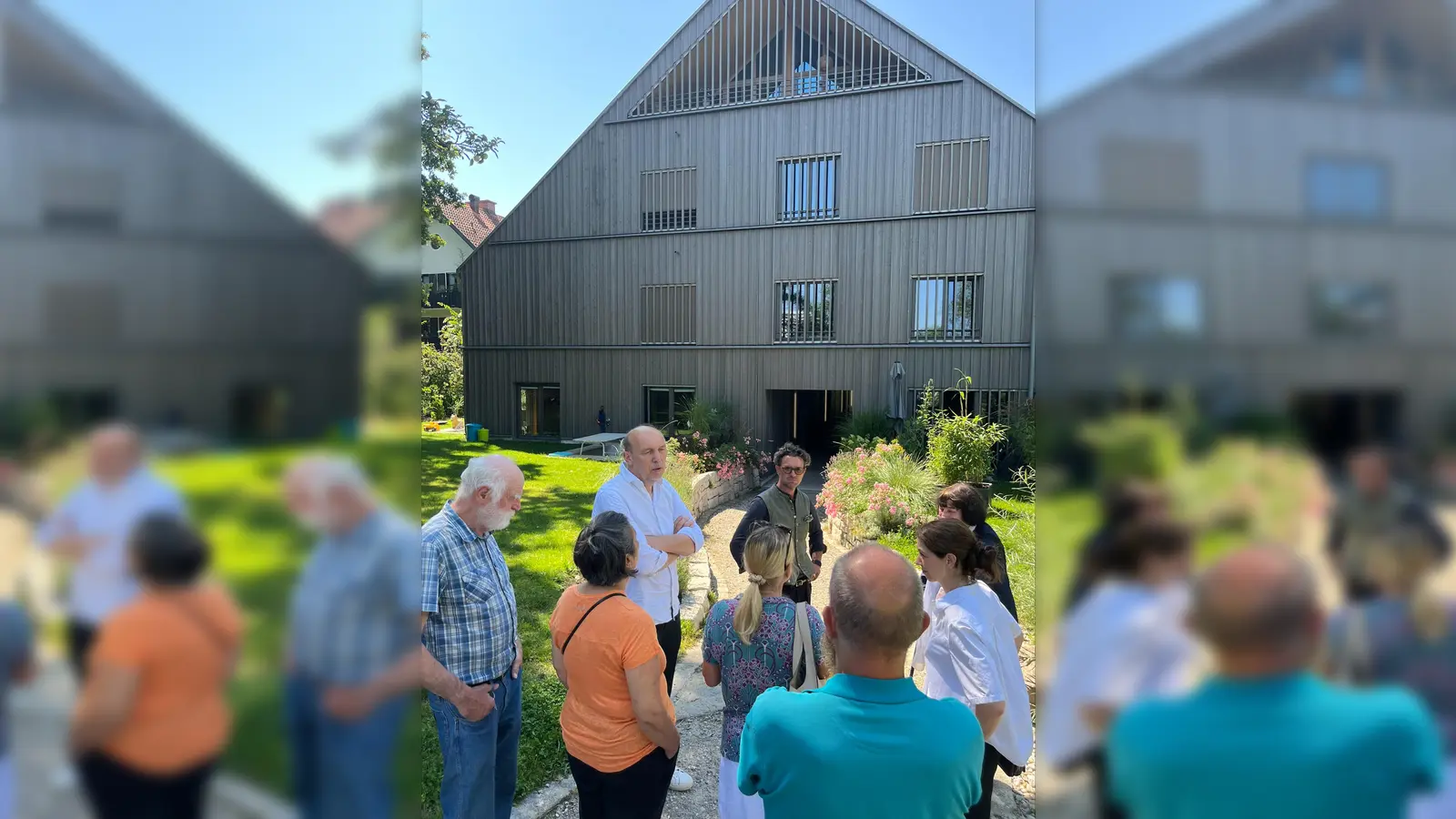 Der Derzbachhof mit Besuchergruppe, Architekt Peter Haimerl und Verwalter der Gemeinschaftsflächen Simon Weber von Qonzep zusammen mit Grünen Politikern.  (Foto: Vorbrugg/Denhauser)