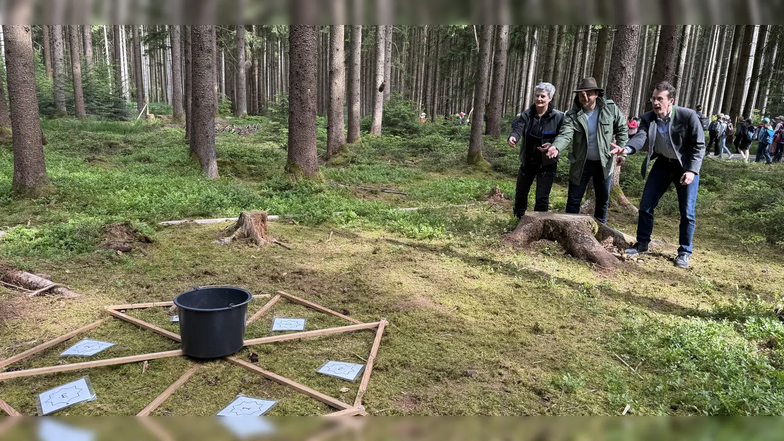 Försterin Christine Achhammer, Revierleiter Harald Appelt und Landrat Stefan Frey (v.l.) probieren das Zapfenweitwerfen. (Foto: pst)