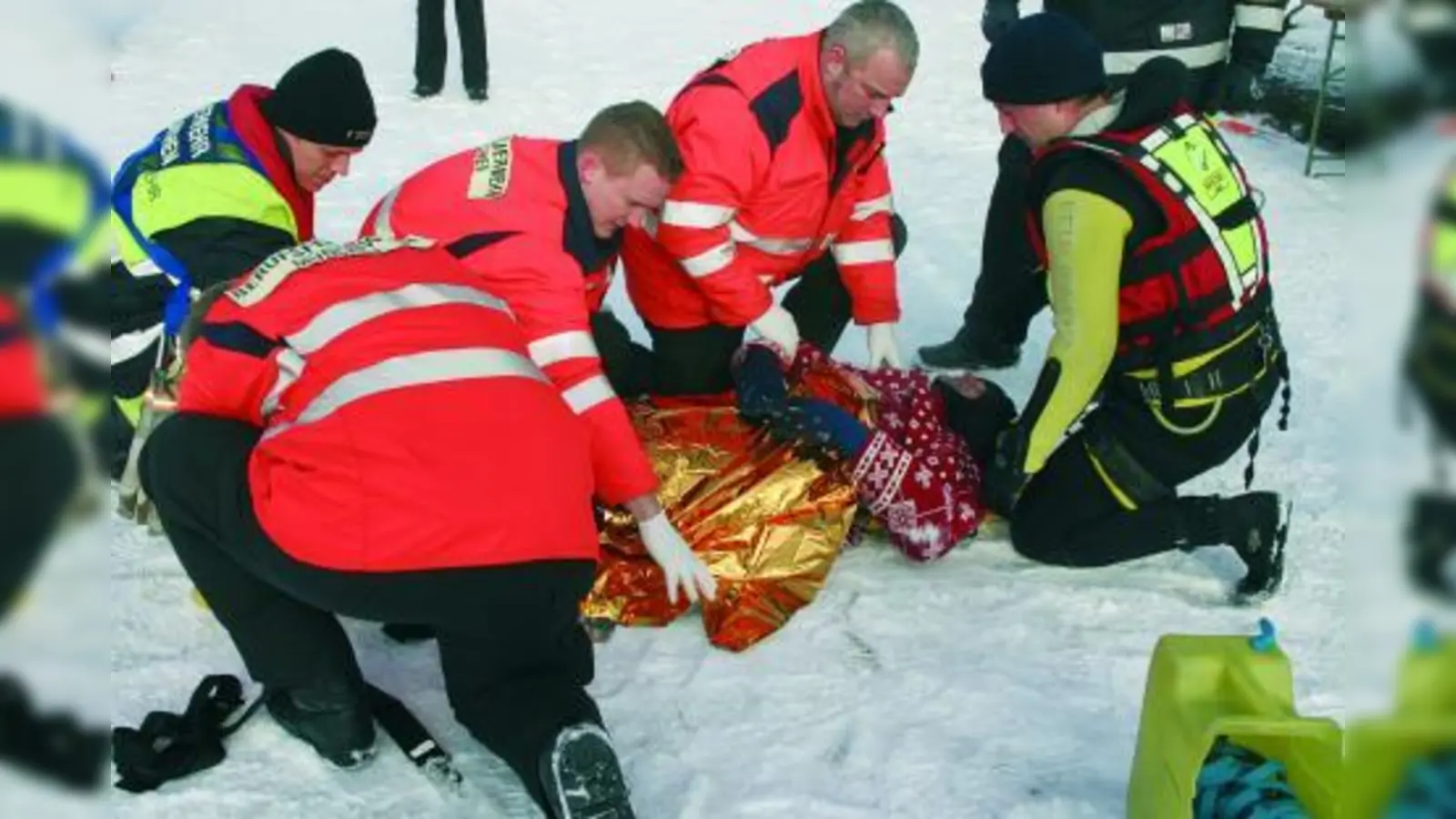 Die Rettungssanitäter versorgen die eingebrochene Person am Ufer und haben sie in eine Rettungsdecke gewickelt. (Foto: cm)