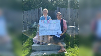 Kita-Leiterin Daniela Binder (links) und Kinderpflegerin Natascha Scheuring freuen sich, die Spende mit der „Schnapszahl“ 333,33 übergeben zu dürfen. (Foto: Kita Wielenbach)