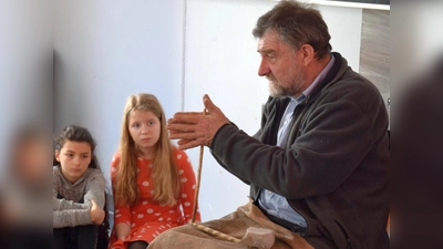 Der Archäologe und Steinzeitexperte Lothar Breinl demonstrierte Schülerinnen des MTG eine Methode, wie in der Steinzeit Feuer gemacht wurde. (Foto: MTG)
