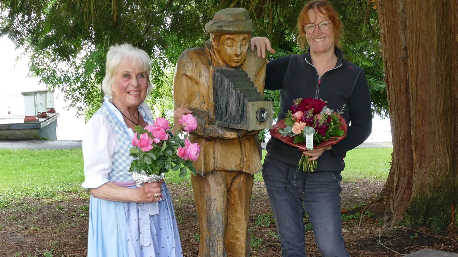 Rita Enzinger, die Koordinatorin von „Künster für Senioren”, und Stefanie von Quast zwischen dem „Fotografen Fritz”, der seit 2023 den Schlosspark zierte.  (Foto: Karin Windorfer)