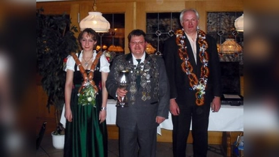 Eingerahmt von Wurstkönigin Monika Pallast und Brezenkönig Franz Felbermeier nahm Walter Schuller als neuer Schützenkönig der SG Langwied den ersten Schluck aus dem Kelch. (Foto: Doris Slavko)