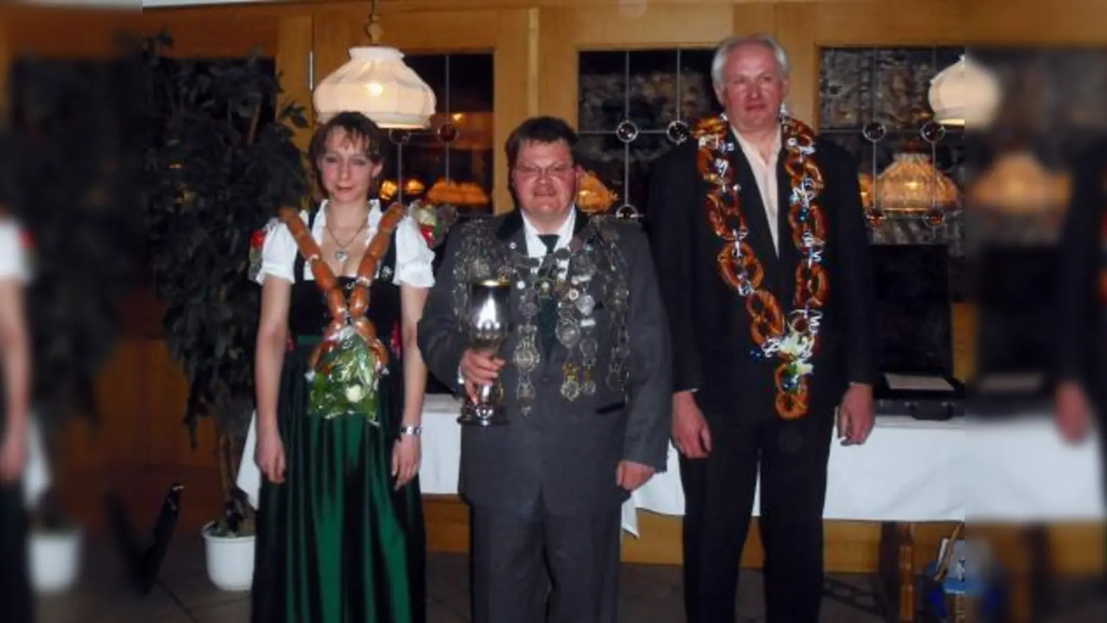Eingerahmt von Wurstkönigin Monika Pallast und Brezenkönig Franz Felbermeier nahm Walter Schuller als neuer Schützenkönig der SG Langwied den ersten Schluck aus dem Kelch. (Foto: Doris Slavko)