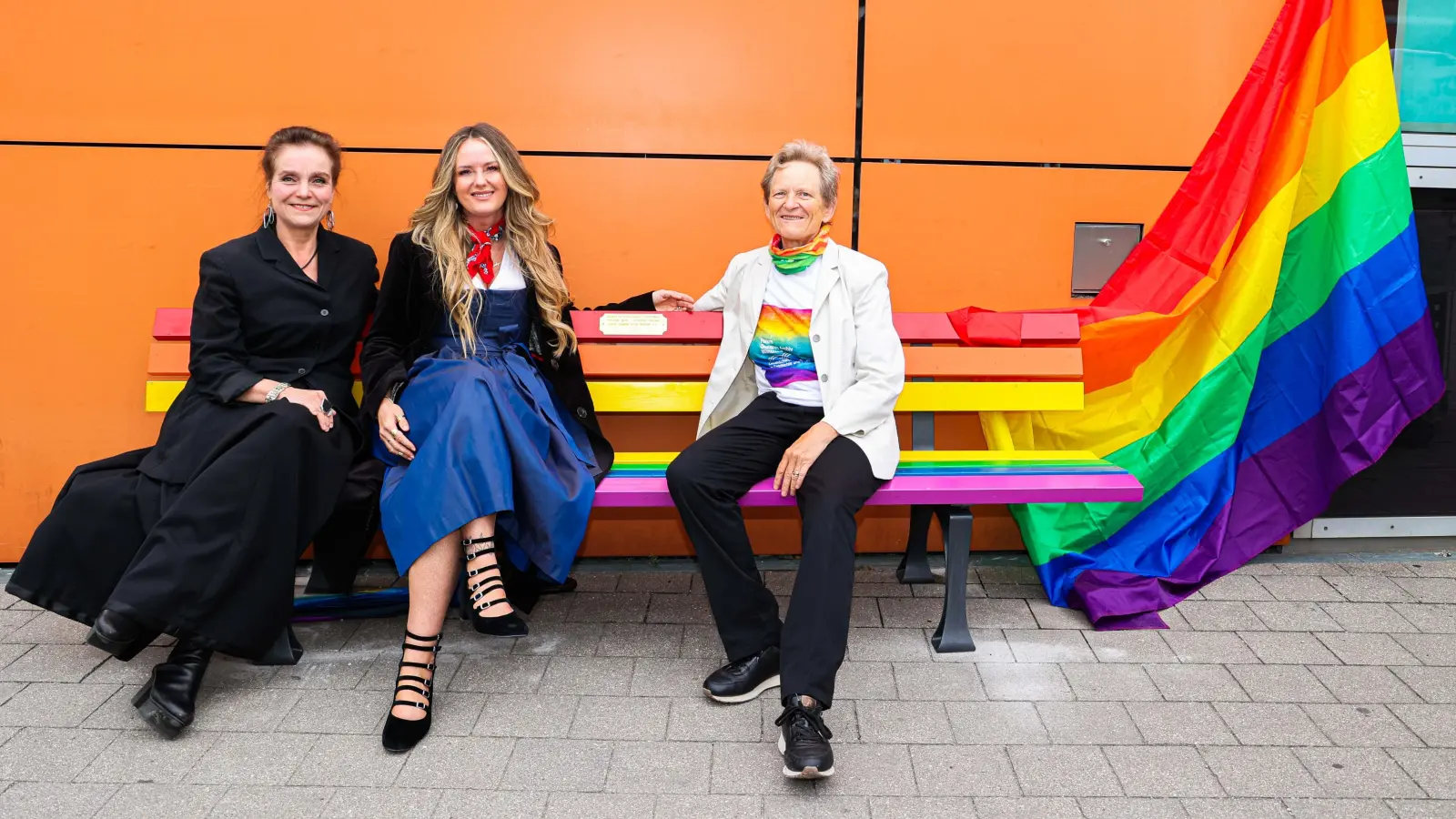 Baureferentin Jeanne-Marie Ehbauer, die Zweite Bürgermeisterin, Mona Fuchs, und Ariane Rüdiger vom Forum Queeres Archiv München (v.l.n.r.) stellen die neue Sitzbank am Curt-Mezger-Platz vor. Die Bank soll Zeichen für Vielfalt und Toleranz sein.  (Foto: Michael Nagy)