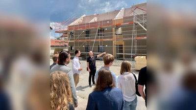 Wohnbau-Geschäftsführer Florian Steinbach (Mitte) erklärte dem JU-Vorsitzenden Julius Ferg (links) und Besucherinnen und Besuchern die Entwicklung der Bauarbeiten am Barbarahof. (Foto: JU Weilheim-Schongau)