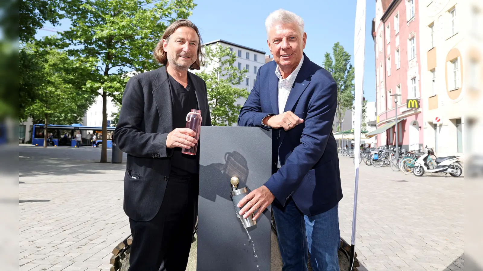 Oberbürgermeister Dieter Reiter (rechts) und Florian Hochstätter, Leiter der Abteilung Gartenbau im Baureferat, zapfen Wasser vom neuen Trinkwasserbrunnen am Harras. (Foto: Michael Nagy/Presseamt)