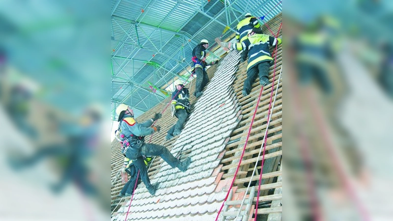 Mitglieder von Feuerwehr und Burschenverein beim Abdecken des Kirchendaches. (Foto: Frieder Vogelsgesang)