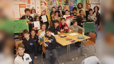 Stolz zeigen die Mädchen und Jungen der 5g, die von ihnen gebastelten Sterne und Kerzenhalter zur Dekoration des Nikolaus-Kuchenbasars – Unterstützung und Lob für die schönen Bastelarbeiten erhielten sie von Klassleiterin Iris Braun (rechts), Susan Golla und Marcel Plank. (Foto: Eva Schraft)