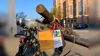 Das Gedicht „Selfie mit Mundschutz“ von Thomas Glatz hängt an einem verwaisten Radl gegenüber der Heilig-Kreuz-Kirche in Giesing. (Foto: Poesieboten)