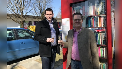 BA-16-Chef Thomas Kauer und der Vorsitzende des Vereins „Leben in Waldperlach“, Andreas Burkhardt stießen auf die Eröffnung des ersten „Offenen Bücherschranks“ in Waldperlach an. (Foto: hw)