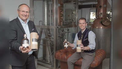 Die ersten Flaschen in den Händen haltend: Bürgermeister Christian Schiller (links) und Achim März in der Distillery „HeiligenBergFeld“. (Foto: Gemeinde Herrsching)