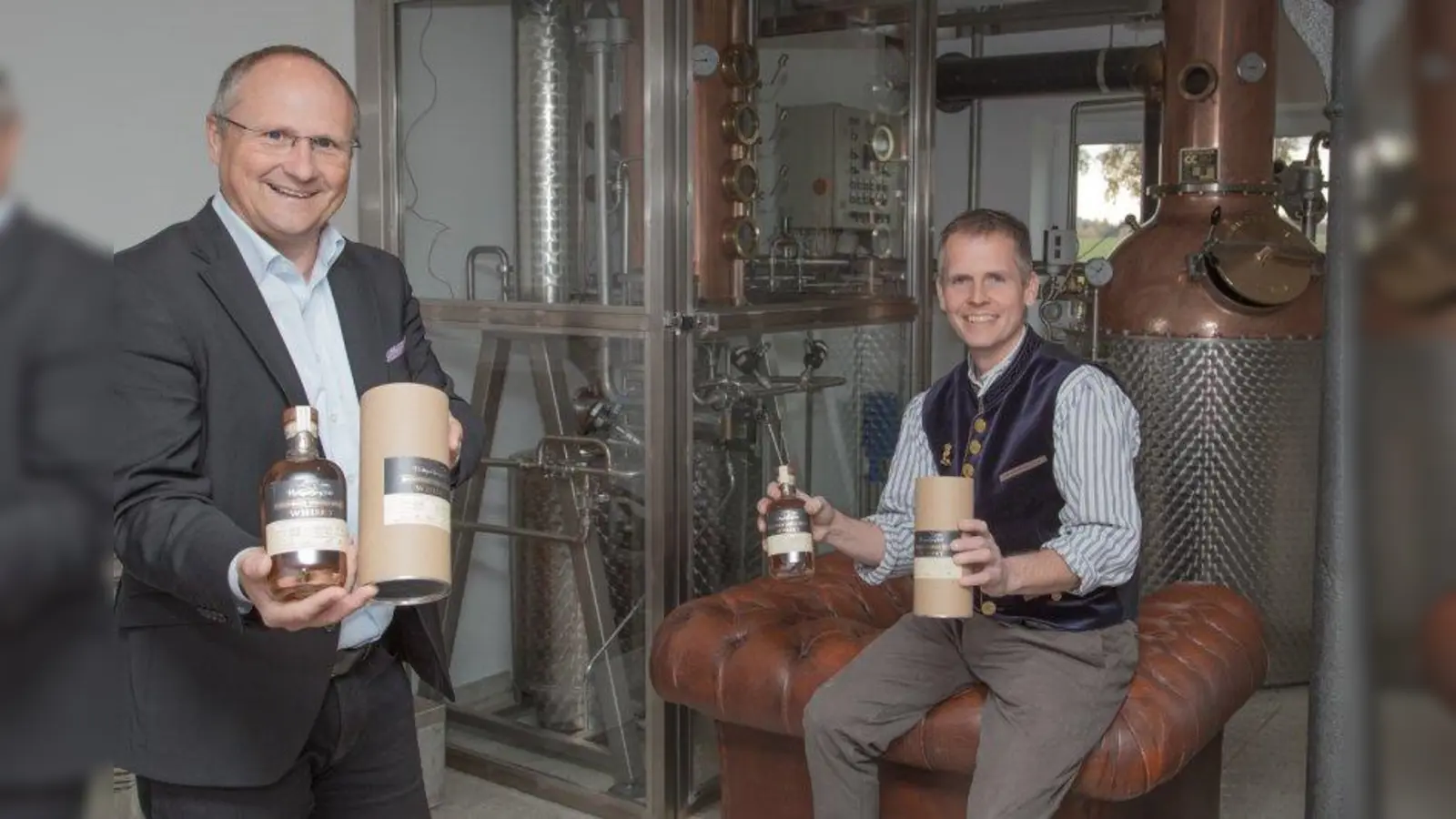 Die ersten Flaschen in den Händen haltend: Bürgermeister Christian Schiller (links) und Achim März in der Distillery „HeiligenBergFeld“. (Foto: Gemeinde Herrsching)