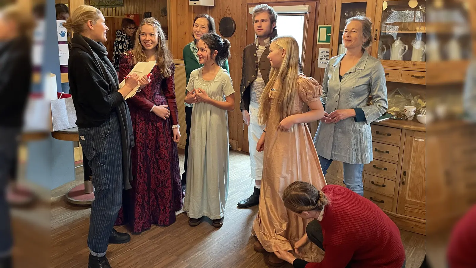 Theatercoach Sophie Hechler (li.) bespricht mit den Schauspielern ihre Rollen. Hinten li. ist Ulrike Roos. Auf dem Boden knieend steckt Brigitte Günczler einen Saum ab.  (Foto: pst)