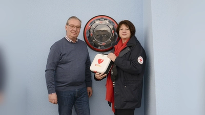 BRK Kreisgeschäftsführerin Elisabeth Seibl-Kinzlmaier installierte zusammen mit Friedrich Peschel einen neuen AED (Automatischer Externer Defibrillator). (Foto: BRK Ebersberg)