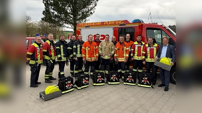 Landrat Robert Niedergesäß mit den Vertretern der Kreisbrandinspektion der Feuerwehren Forstinning, Anzing, Purfing, Pöring, Eglharting, Kirchseeon Markt, Ebersberg und Hohenlinden bei der Übergabe der „Waldbrandrucksäcke“. (Foto: Landratsamt Ebersberg)