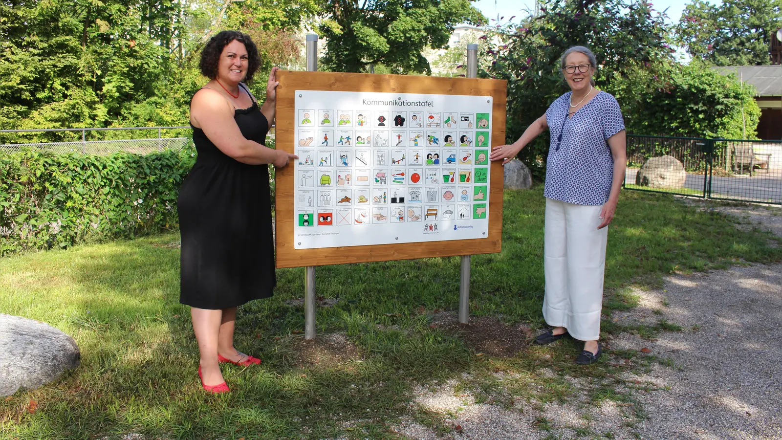 Inklusionsbeiratsmitglied Elisabeth Kraft (links) und Dritte Bürgermeisterin Christiane Falk neben<br>einer der neuen Kommunikationstafeln am Spielplatz Nepomuk im Bucentaurpark. (Foto: Stadt Starnberg)