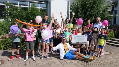 Clown Dr. Batscho (vorne) freute sich über das große Engagement der Schülerinnen und Schüler - und über einen Scheck über 11.700 Euro. (Foto: Lionsclub Aschheim)