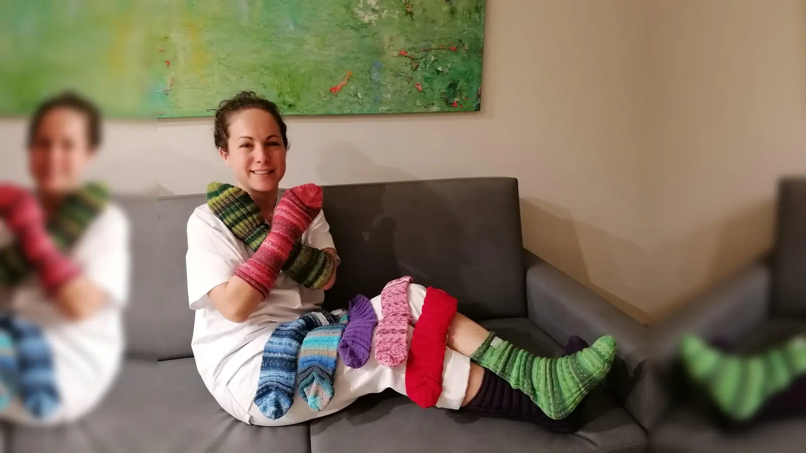 Viviana Dasch, Gesundheits- und Krankenpflegerin der Palliativstation, zeigt die Bettsocken für Patienten, die ihre Kollegin Birgit Berthold gestrickt hat. (F.: Kreisklinik Ebersberg)